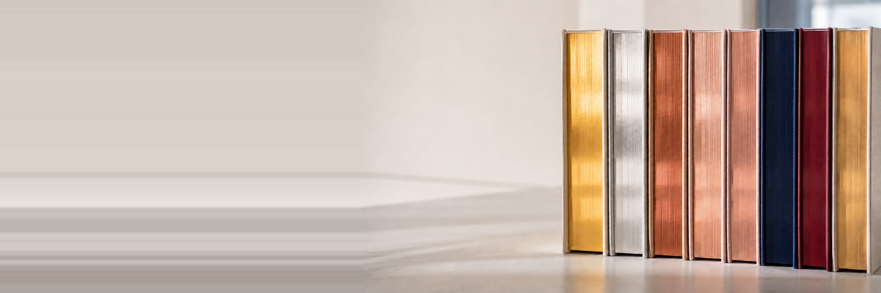 Hardcover books with gold, silver, copper, rose gold, navy, and burgundy finished page edges.